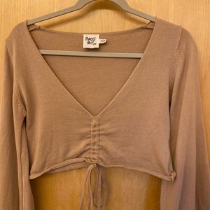 Deep V cropped light sweater with bell sleeves. Adjustable ties around bottom